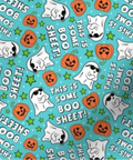 A close-up of a Halloween-themed fabric pattern featuring white cartoon ghosts, orange jack-o'-lanterns, green stars, and white text reading 'THIS IS SOME BOO SHEET!' on a bright aqua background.
